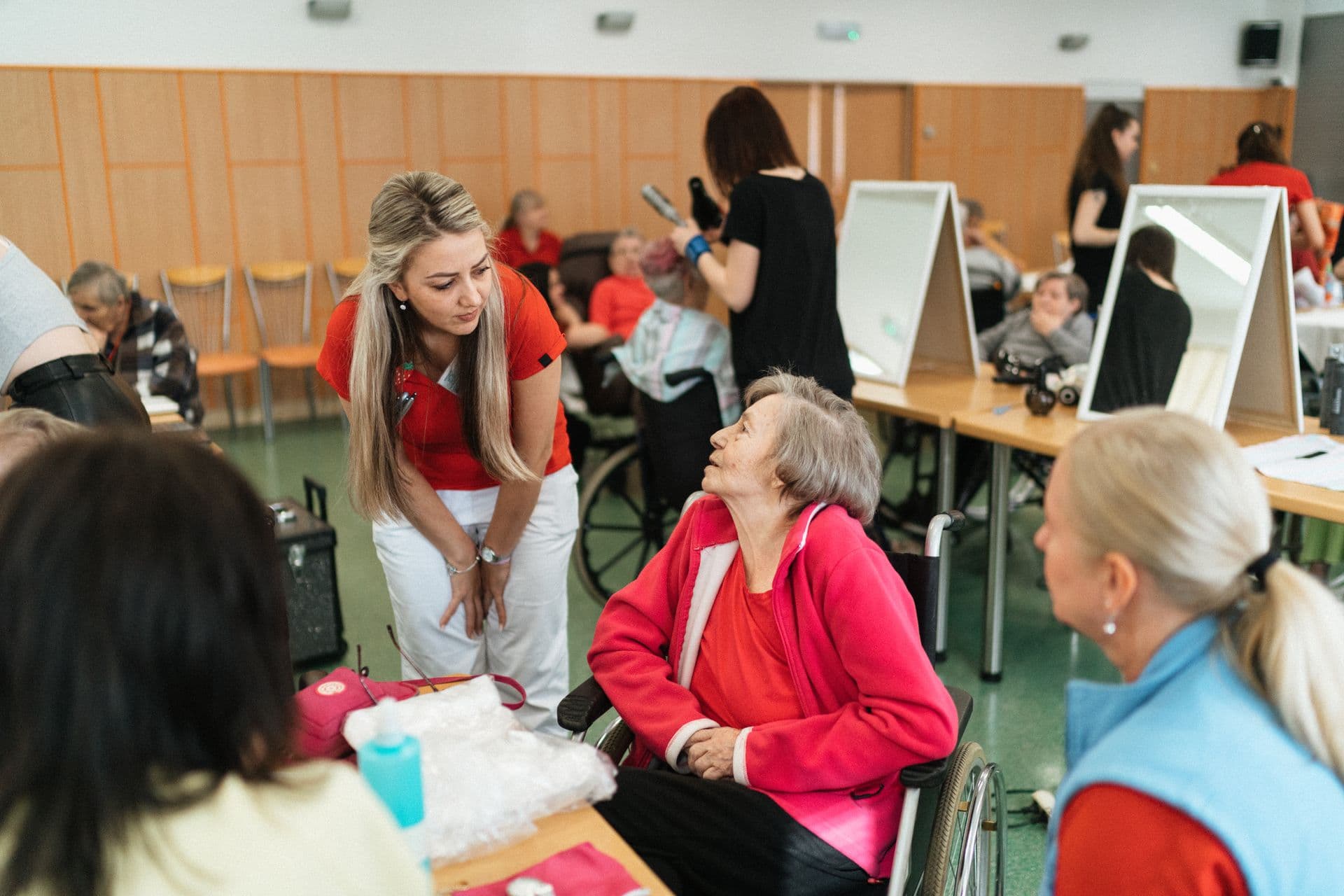 A caregiver speaking with a resident during a group activity